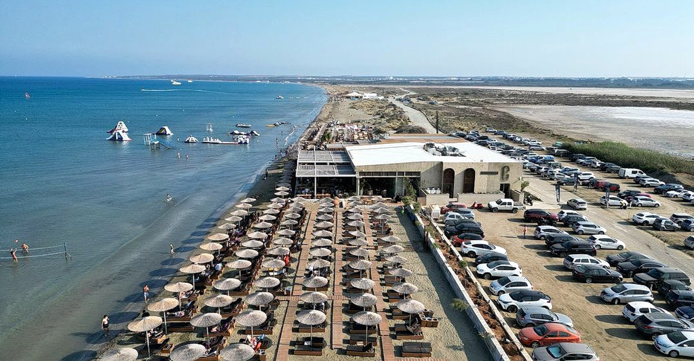 Lady's Mile on the Akrotiri peninsula: kilometres of flat hard-packed sand with shallow water and kitesurfers in the distance